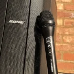 AKG microphone positioned next to Bose speaker for live announcements at event setup