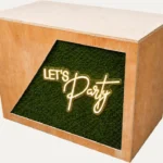 Wooden DJ booth with Let’s Party neon sign for weddings and private events