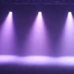 Purple stage spotlights shining through haze for event lighting and performance setups