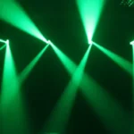 Green moving head lighting beams cutting through haze for high-energy event lighting hire