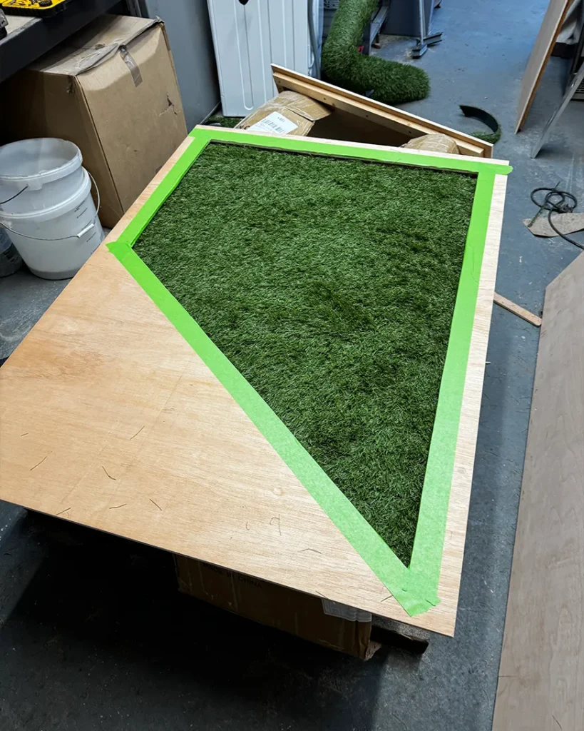 Custom exhibition stand build in progress with artificial grass feature panel