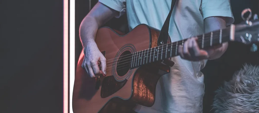 Acoustic guitarist performing live at a small event or intimate venue