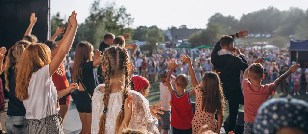 Children and families dancing at an outdoor community event