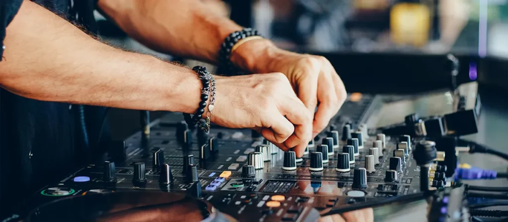 DJ adjusting a professional mixing controller for event music and DJ equipment hire