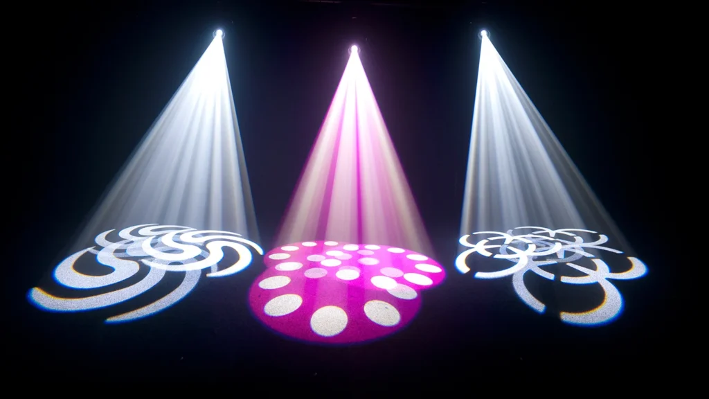 White and pink Chauvet Intimidator Spot 350 beams with circular gobo patterns on a dark floor