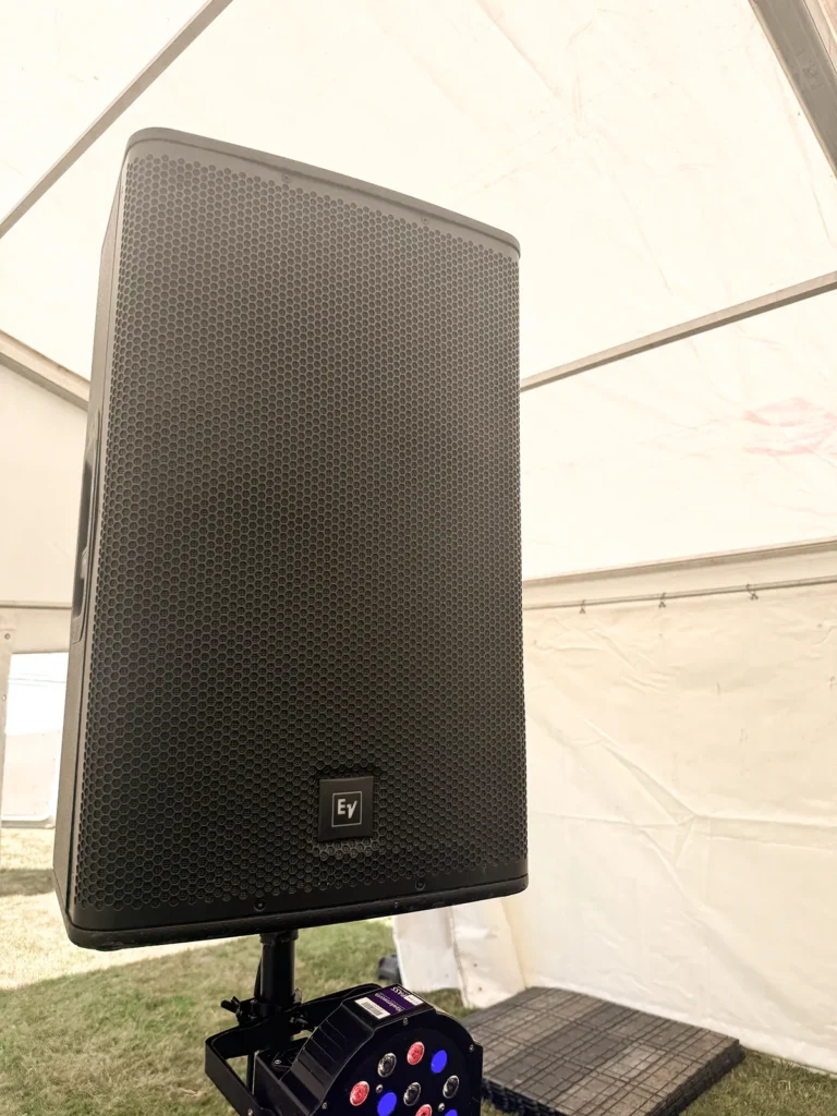 EV PA speaker on stand with LED party light set up inside a marquee for event sound and lighting hire