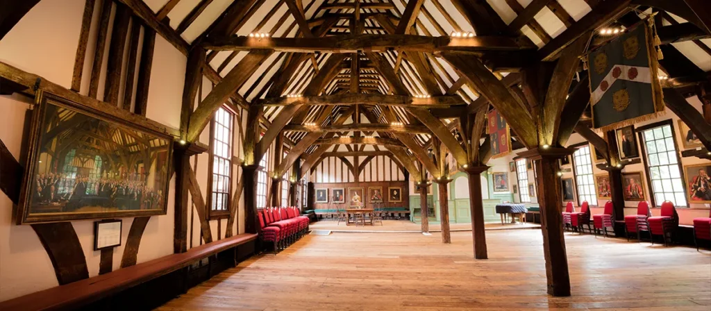 Historic timber-framed event hall with open floor space, seating and warm lighting for weddings and private functions